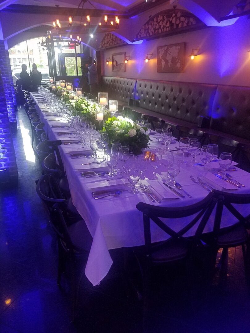 Main Room Event Space 1 A long table with many plates and candles on it