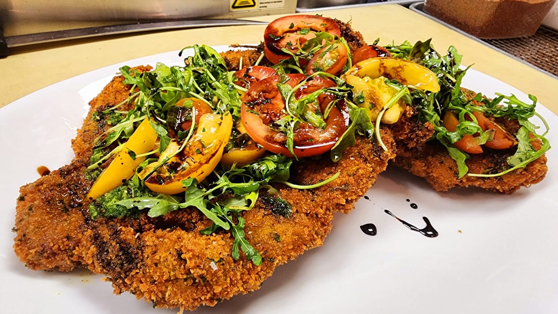 veal milanese A plate of food with some meat and vegetables